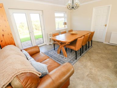 A dining room with a large table and chairs at 24 Little Castle Grove in Hubberston