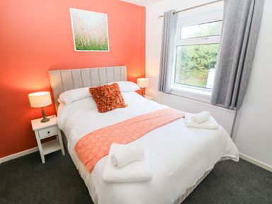 A bedroom with a bed and nightstand at 24 Little Castle Grove in Hubberston