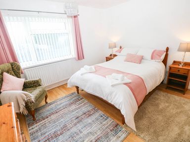 A bedroom with a bed and armchair at 24 Little Castle Grove in Hubberston