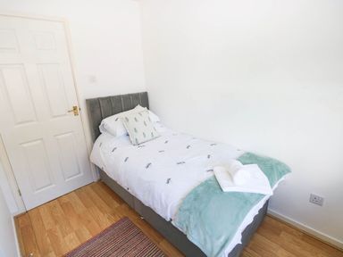 A bedroom with a single bed and a door at 24 Little Castle Grove Hubberston