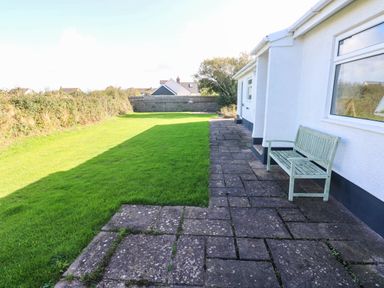 A garden with a bench and patio area at 24 Little Castle Grove Hubberston