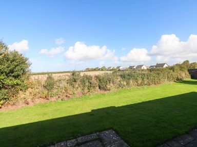 A field with grass and houses in the distance at 24 Little Castle Grove Hubberston
