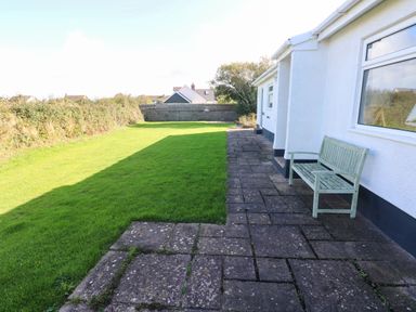 A garden with grass and a bench at 24 Little Castle Grove Hubberston