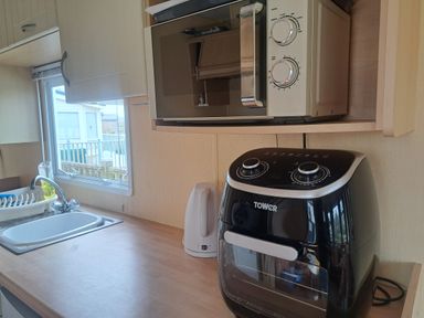 A kitchen with a microwave and air fryer at Chapel Farm Holiday Park No 6 Bunnies View Appleby-in-Westmorland
