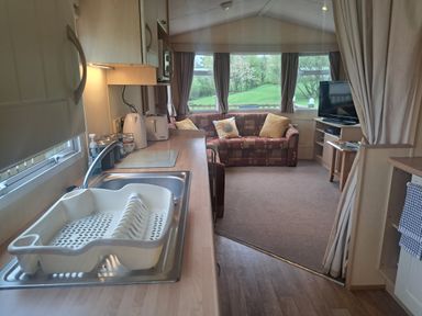 A kitchen and living area with sink and sofa at Chapel Farm Holiday Park No 6 Bunnies View Appleby-in-Westmorland
