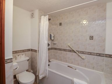 A bathroom with a shower and bathtub at Moorhen in Kingsteignton