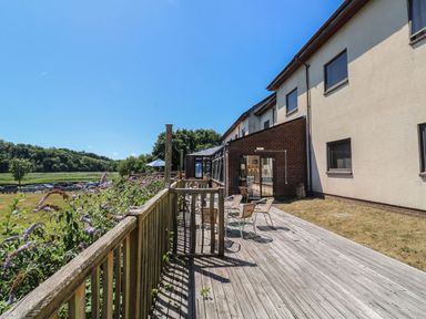 An outdoor area with a deck and chairs at Moorhen in Kingsteignton