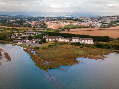 A river with buildings and fields at Moorhen in Kingsteignton