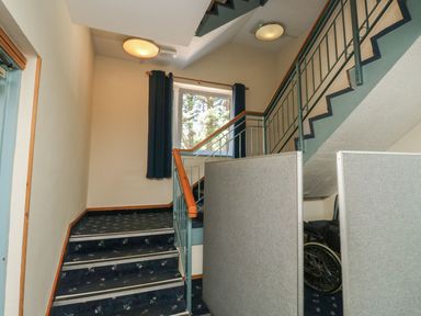 A staircase with a handrail and wheelchair at Moorhen in Kingsteignton