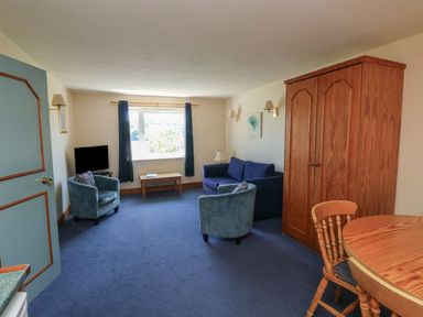 A living room with a sofa and armchair at Nightjar in Kingsteignton