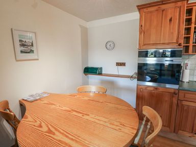 A kitchen with wooden table and chairs at Nightjar in Kingsteignton