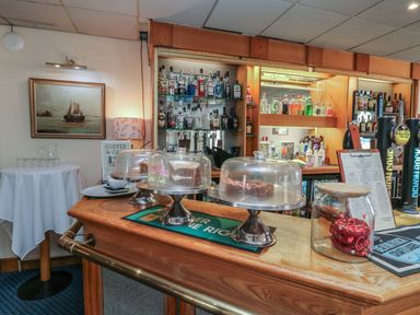 A bar area with cakes and drinks at Nightjar in Kingsteignton