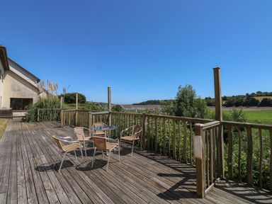 A deck with a table and chairs at Guillemot in Kingsteignton