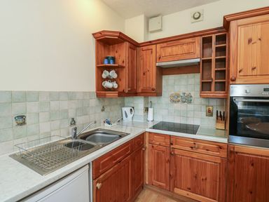 A kitchen featuring a sink, cabinets, and stove at Egret in Kingsteignton