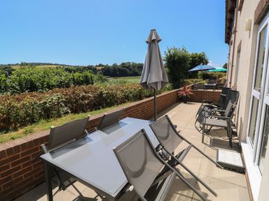 An outdoor area with a dining table and chairs at Egret in Kingsteignton