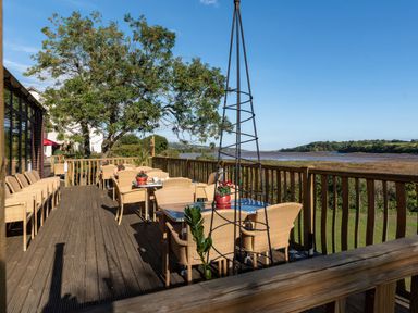 An outdoor seating area with tables and chairs at Egret in Kingsteignton