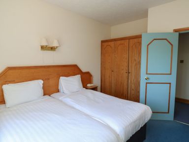 A bedroom with two beds and one wardrobe at Avocet in Kingsteignton