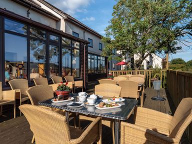 An outdoor dining area with a table set for tea at Avocet in Kingsteignton