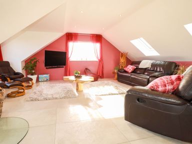 A living room with a sofa and TV at Harber Rise in Carlyon Bay