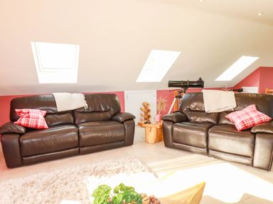 A living room with two sofas and a telescope at Harber Rise in Carlyon Bay