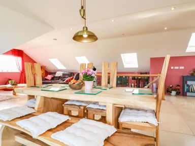 A dining room with a wooden table and chairs at Harber Rise in Carlyon Bay