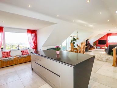 A kitchen and living area with seating and a dining table at Harber Rise in Carlyon Bay