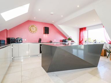 A kitchen with a central island and modern fixtures at Harber Rise in Carlyon Bay