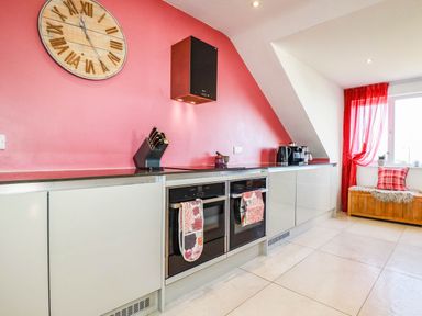 A kitchen with a clock and oven at Harber Rise in Carlyon Bay