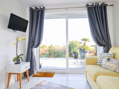 A living room with a yellow sofa and television at Harber Rise in Carlyon Bay