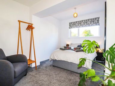 A bedroom with a bed and armchair at Harber Rise in Carlyon Bay