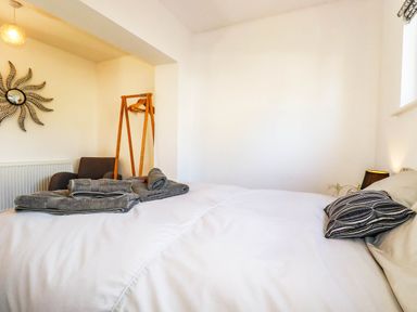 A bedroom with a bed and a mirror at Harber Rise in Carlyon Bay