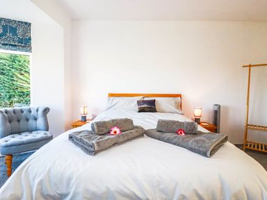 A bedroom with a bed and a chair at Harber Rise in Carlyon Bay
