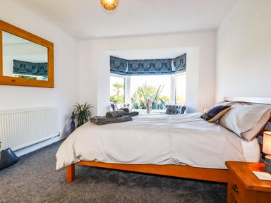 A bedroom with a bed and window at Harber Rise in Carlyon Bay