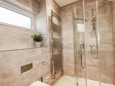 A bathroom with a shower and towel radiator at Harber Rise in Carlyon Bay