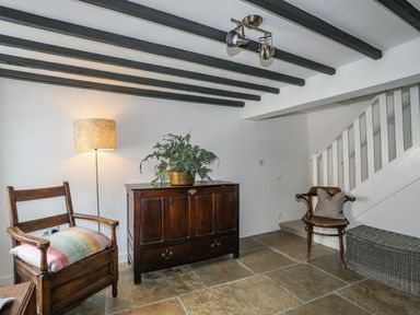 An entryway with a chest of drawers and a chair at Swn y Mor (Wexham), Beaumaris