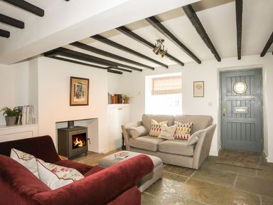 A living room with a sofa and fireplace at Swn y Mor (Wexham) Beaumaris