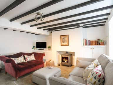 A living room with a sofa, fireplace, and TV at Swn y Mor (Wexham) Beaumaris