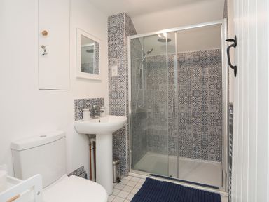 A bathroom with a shower, sink, and toilet at Swn y Mor (Wexham) Beaumaris