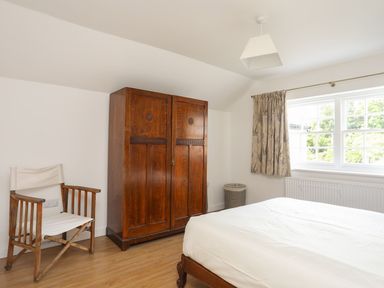 A bedroom with a wardrobe and bed at Swn y Mor (Wexham) Beaumaris