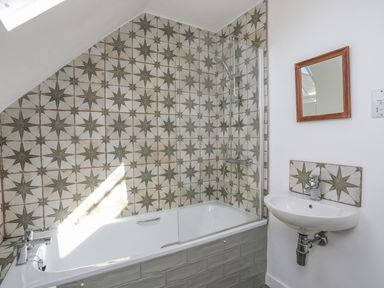 A bathroom with a bathtub and shower at Swn y Mor (Wexham) Beaumaris