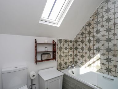 A bathroom with a bathtub and a toilet at Swn y Mor (Wexham) Beaumaris