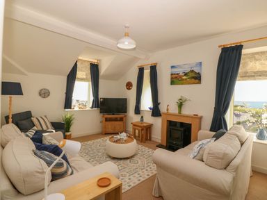 A living room with a television and sofa at Llywelyn in Trearddur Bay