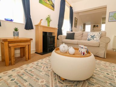 A living room with a sofa and a fireplace at Llywelyn in Trearddur Bay