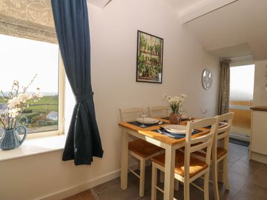 A dining room with a table and chairs at Llywelyn in Trearddur Bay