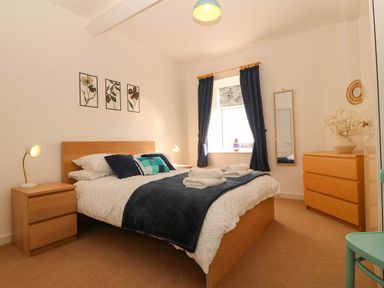A bedroom with a bed and nightstand at Llywelyn, Trearddur Bay