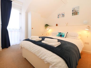 A bedroom with a bed and wardrobe at Llywelyn in Trearddur Bay