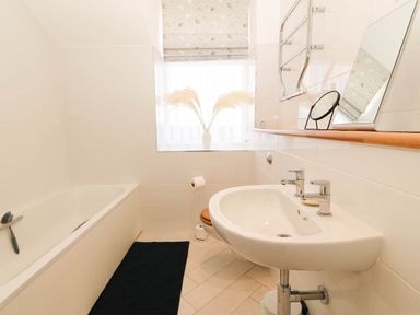 A bathroom with a bathtub and sink at Llywelyn in Trearddur Bay