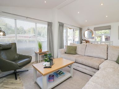A living room with a sofa, armchair, and coffee table at Thirlmere Scar in Troutbeck Bridge