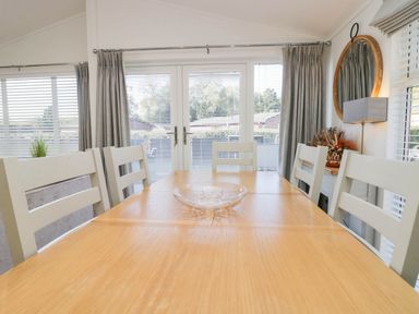 A dining room with a table and chairs at Thirlmere Scar in Troutbeck Bridge