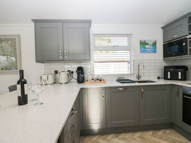 A kitchen with wine glasses and a wine bottle at Thirlmere Scar in Troutbeck Bridge